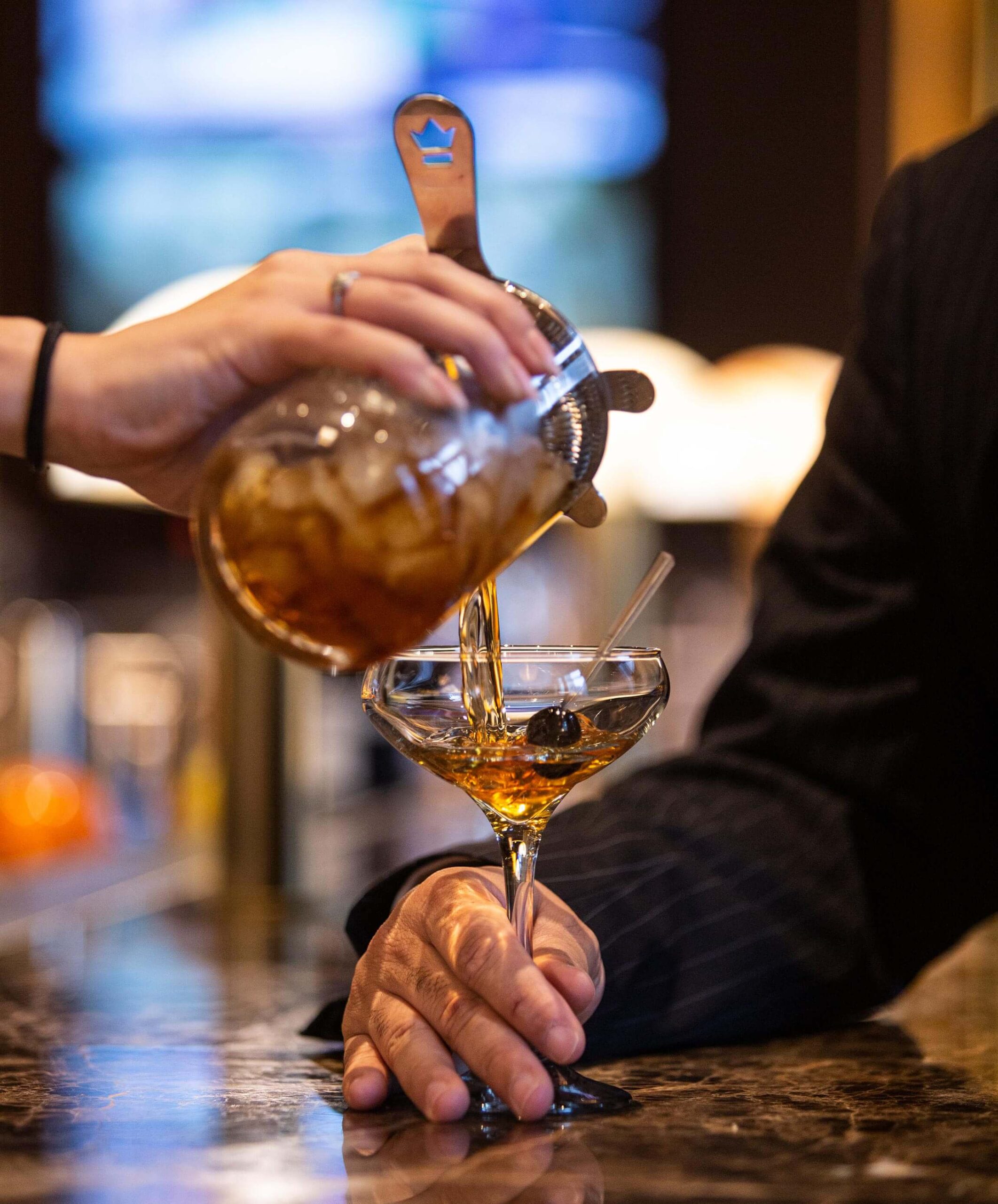 bartender pouring cocktail for diner