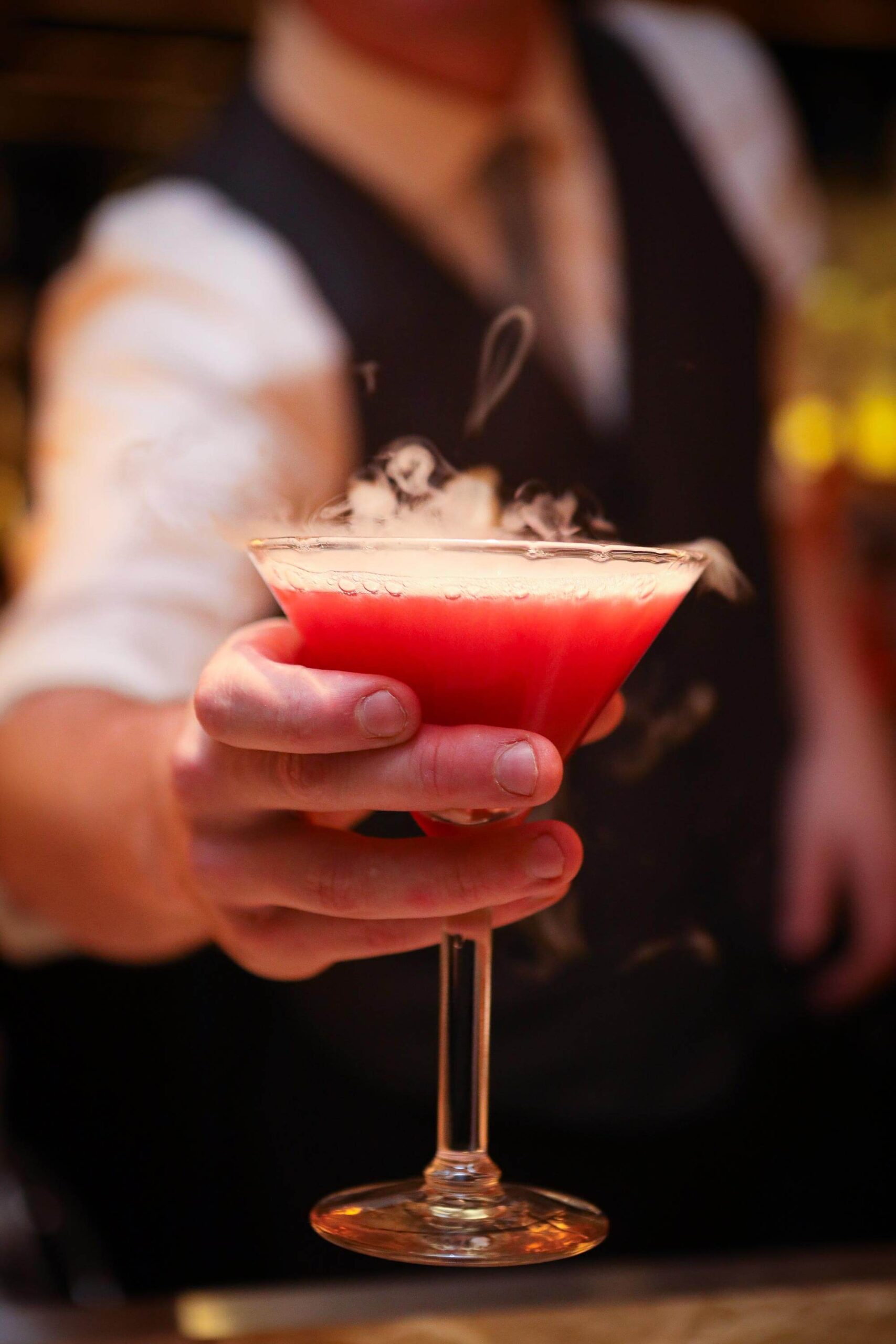 Bartender serving pink martini cocktail